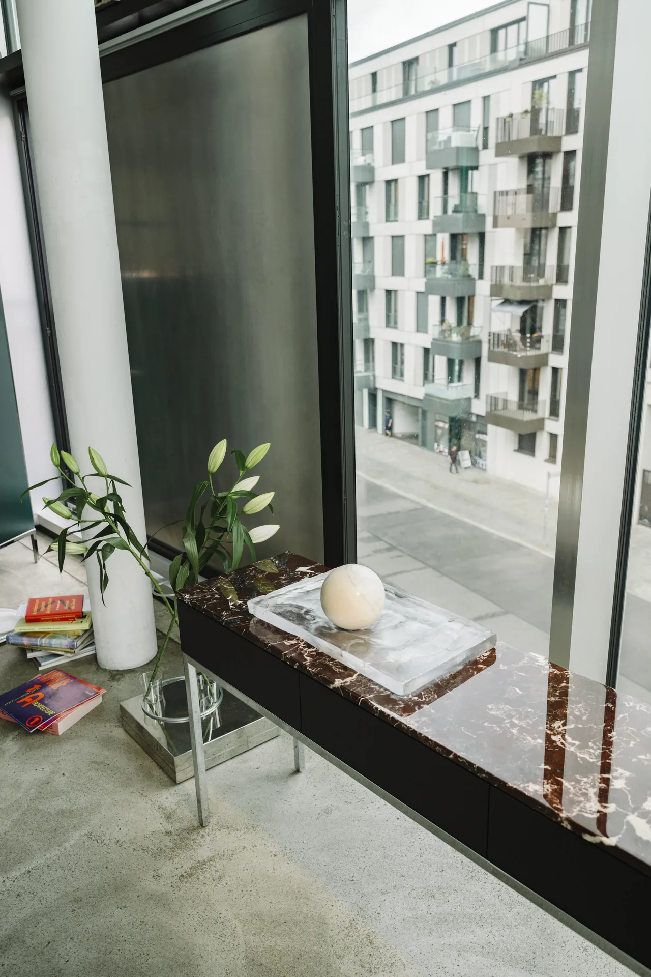 Knoll Chermayeff Storage console table with a marble top and steel legs at a window