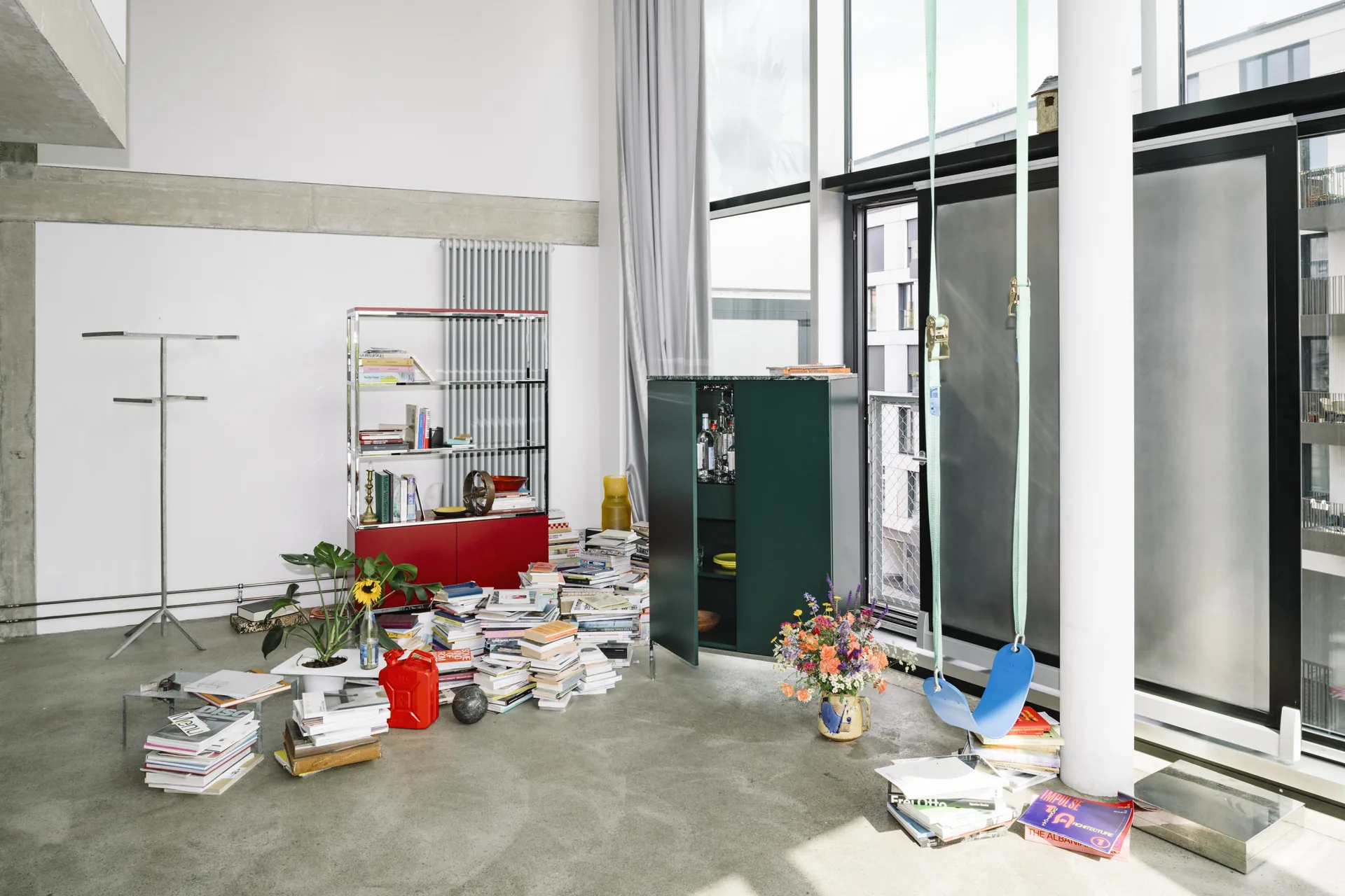 Knoll Chermayeff Storage tall open shelving and green cabinet in a double height loft with books