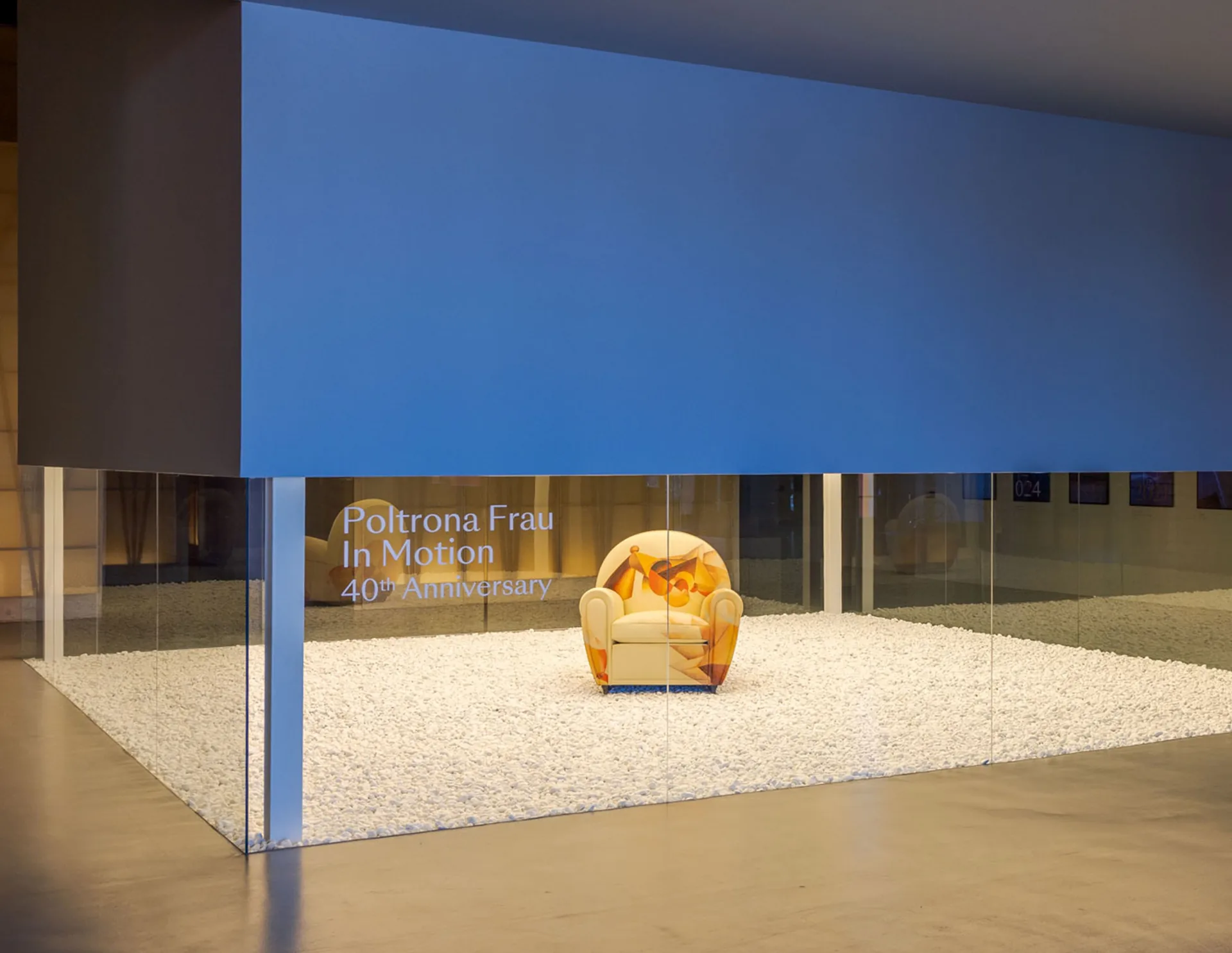 Poltrona Frau: the Vanity Fair XC In Motion armchair in a glass case on white gravel at the Poltrona Frau Museum